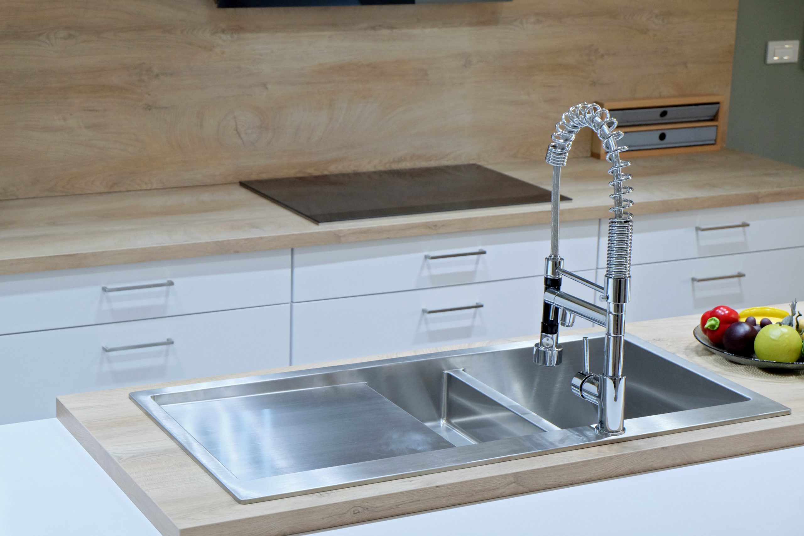 Stainless,Steel,Sink,And,Mixer,Taps,On,Wooden,Worktop,In