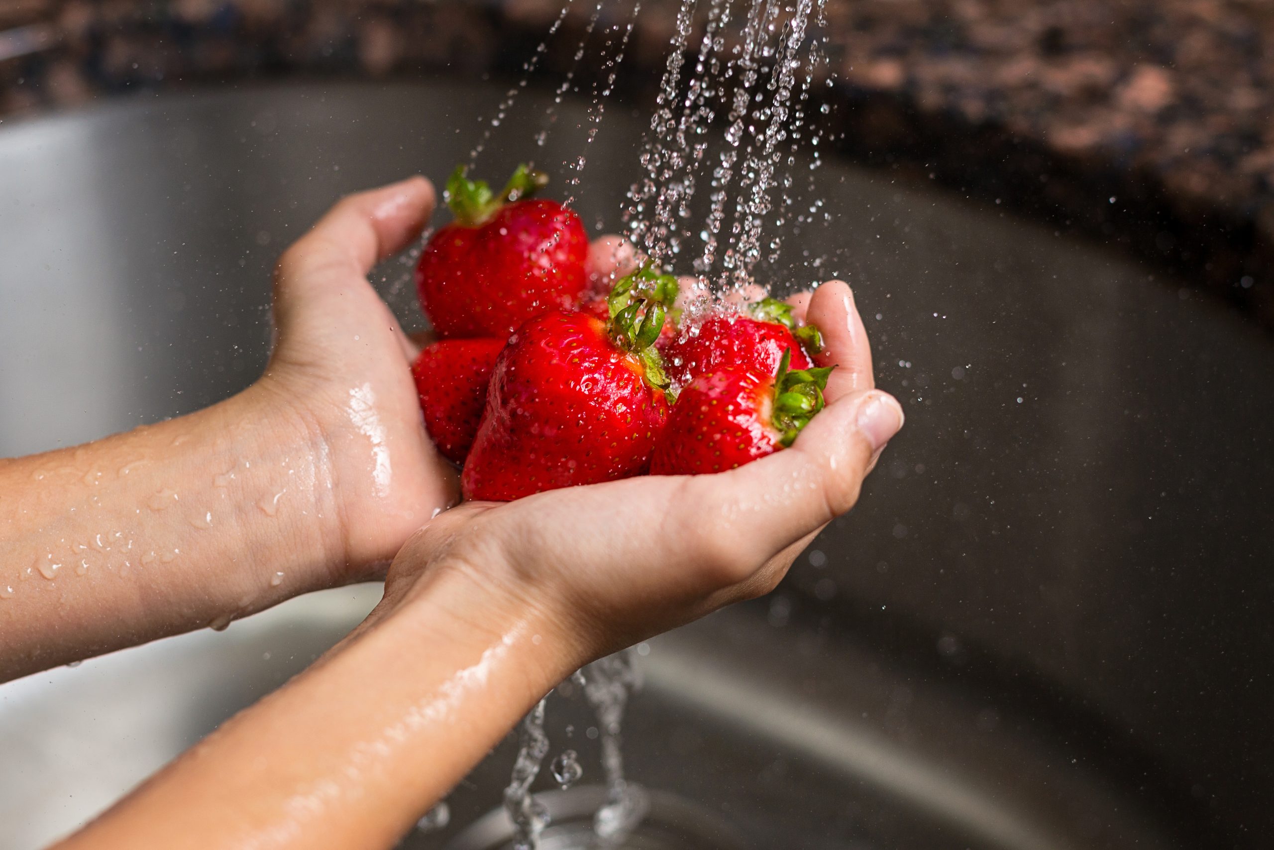 Washing,Strawberries,Under,A,Faucet